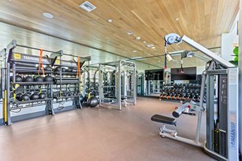 Gym with weights and cardio equipment on the floor and a wooden ceiling
